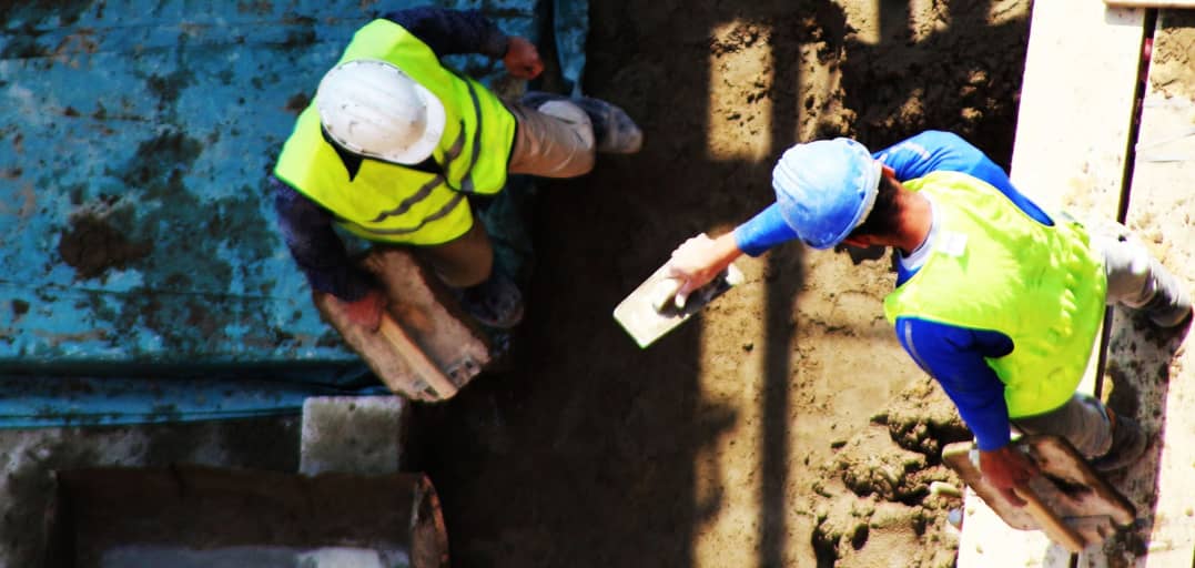 Two construction workers on a job site - aerial view.